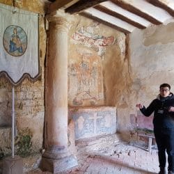 Imagen de persona explicando el interior de la ermita de Faido.