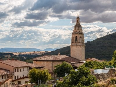 Iglesia de San Pedro de Treviño con casas y entre montañas.